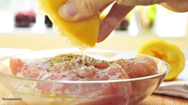 Hand marinating raw chicken breasts مرینیت گوشت با لیمو